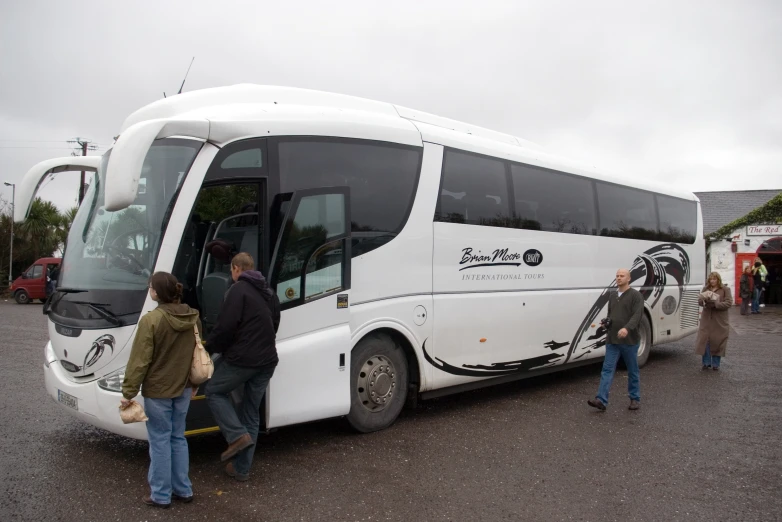 people getting on and off of a tour bus