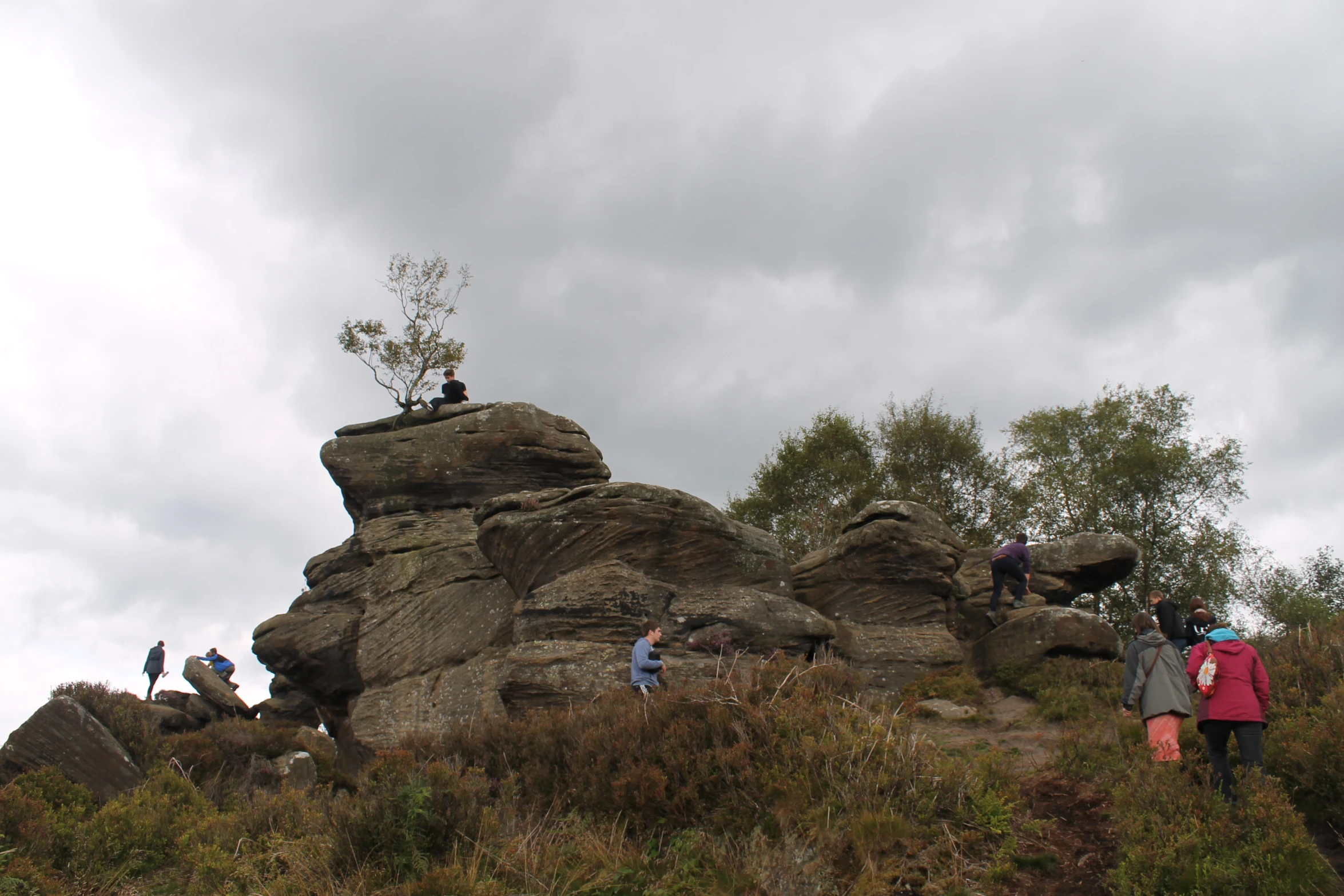 some people hiking up a hill by some rocks