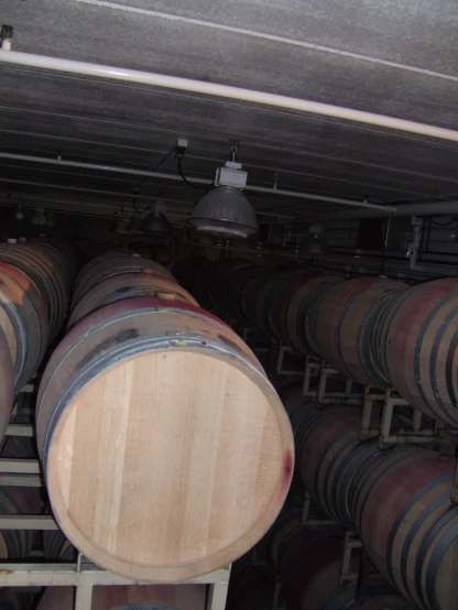 a bunch of wine barrels stacked in a storage room