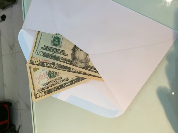 the envelope with a pile of dollar bills is opened