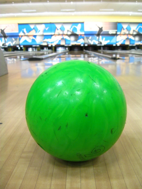 the large green ball is on top of the bowling court