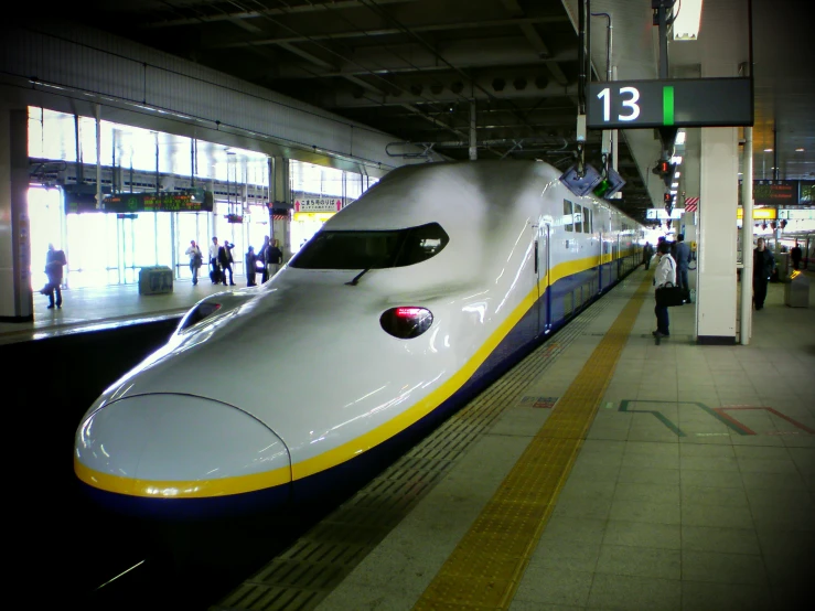 the large bullet train is on its tracks at the station