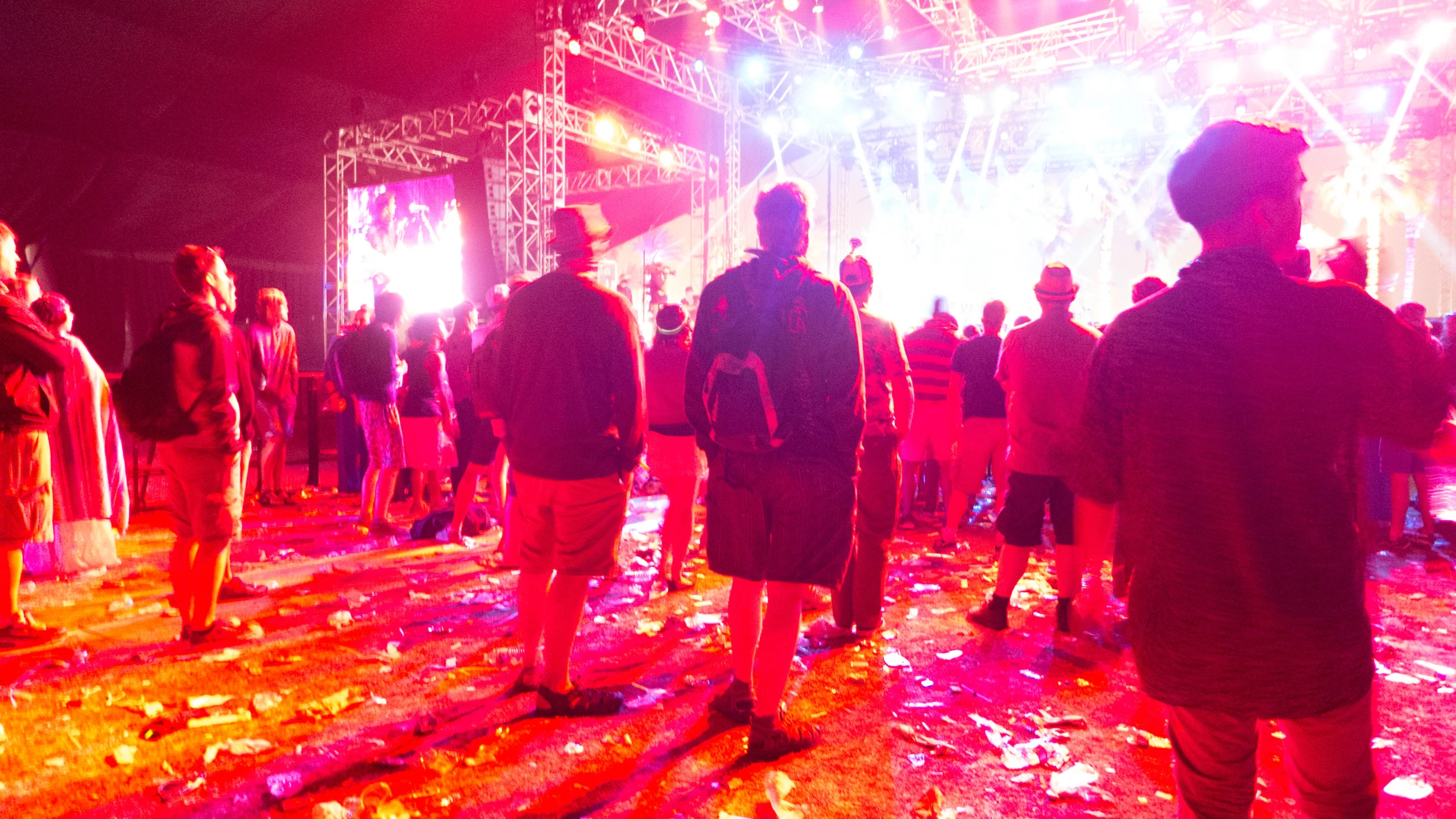 group of people standing around a stage at night