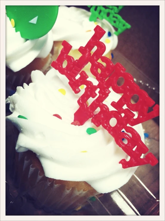 cupcakes with white frosting and a happy birthday letter on top