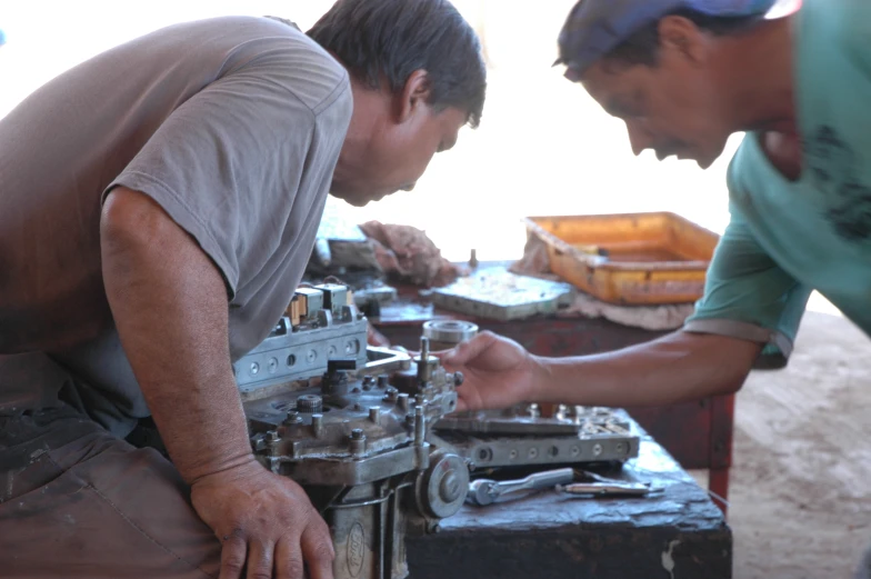 two men are examining a motor engine