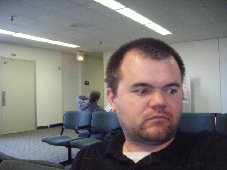 a man sitting in an office waiting for someone to talk