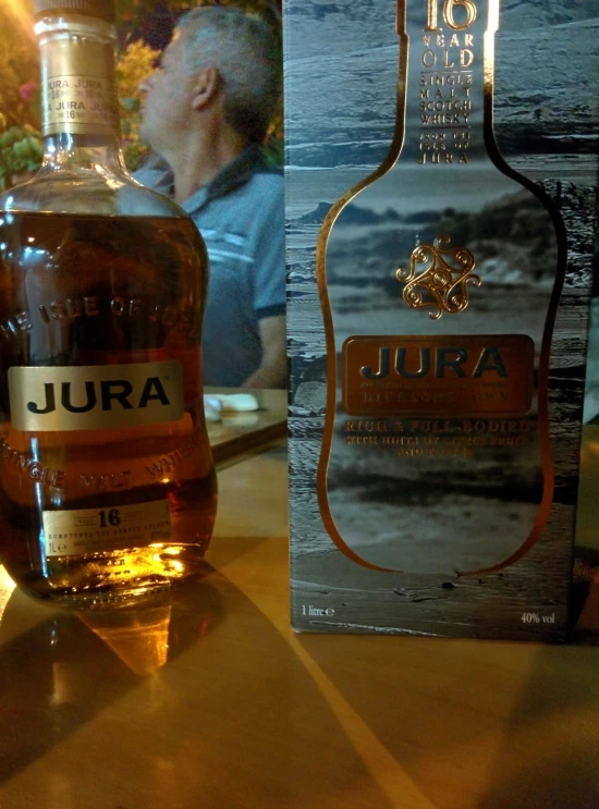 a bottle of jura sitting next to an empty box