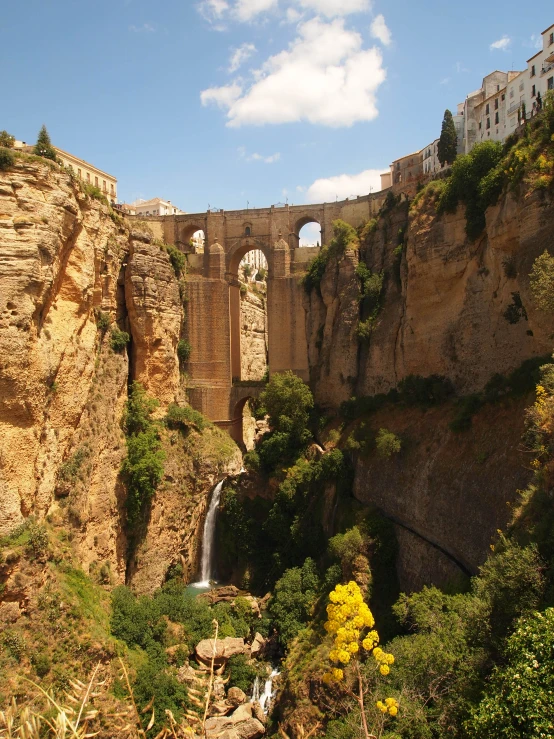 there are two bridges over a canyon with a waterfall in it