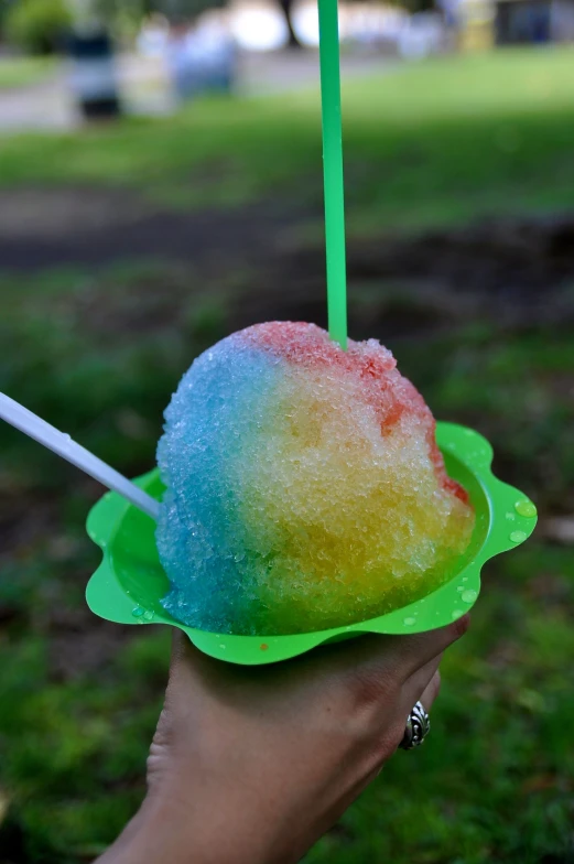 a colorful, popsicle filled with ice cream in a green plastic bowl