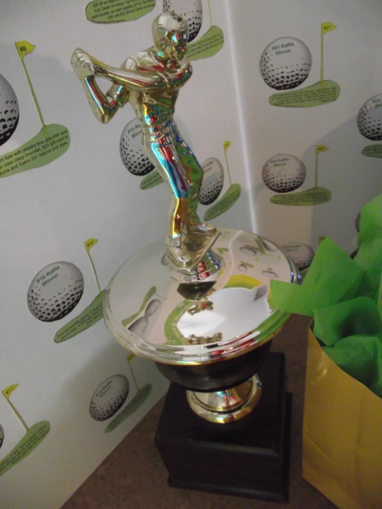 a gold and silver metal trophy on a wooden stand