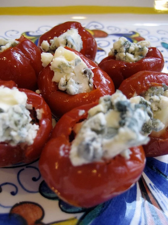 stuffed tomatoes and blue cheese are on a plate