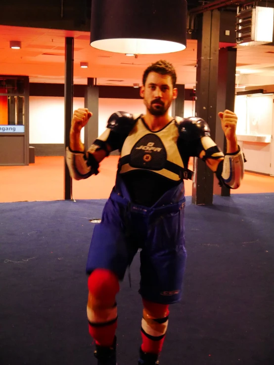 a man posing in the middle of a room with punching gloves