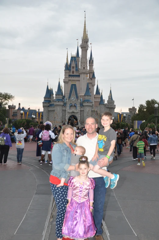 a family taking a picture in front of a castle at the amut park