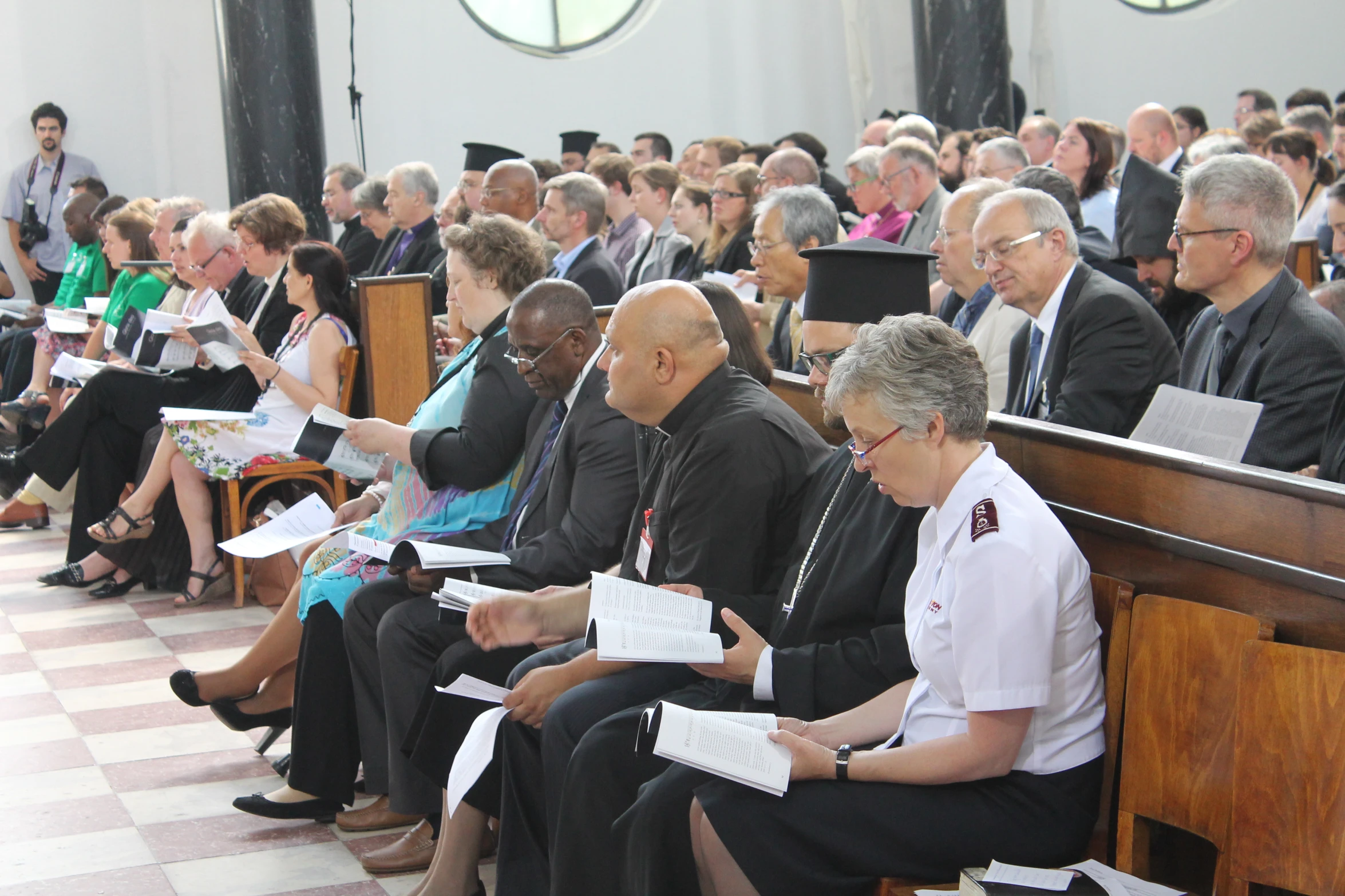 many people are sitting in the pews at a funeral