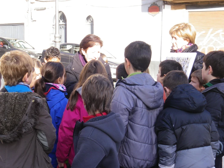 an outdoor crowd of people are talking in front of a building