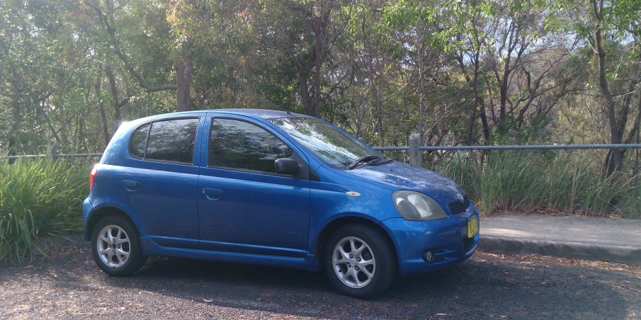 this is an image of a blue car parked on the road