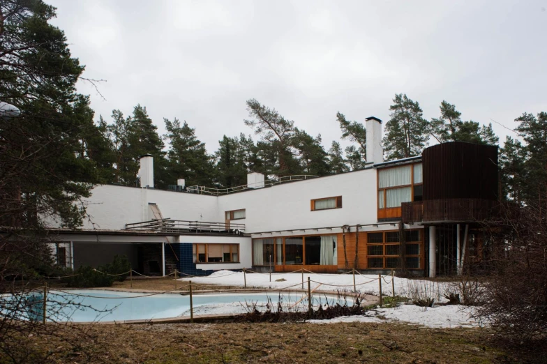 a swimming pool and deck in a yard next to trees