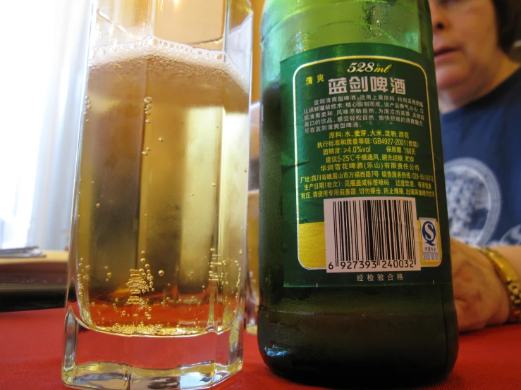 the beer is beside a tall glass with a straw