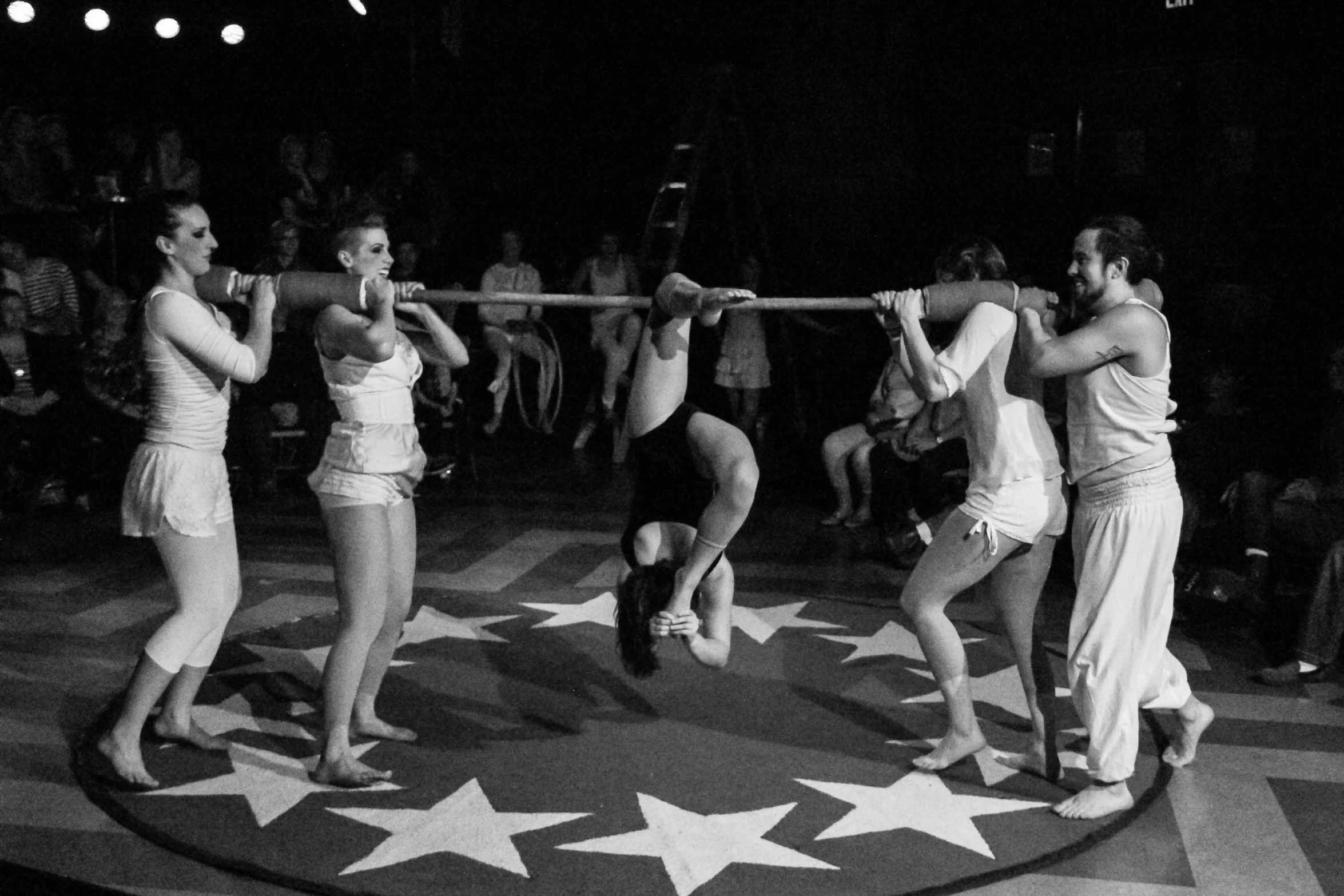 three people doing acrobatic stunts on a star shaped stage