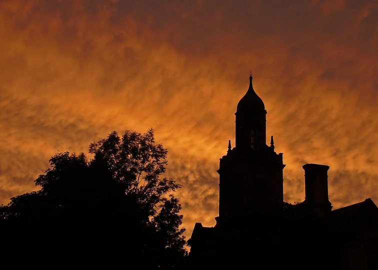 a sunset s looking up at the steeple of a building