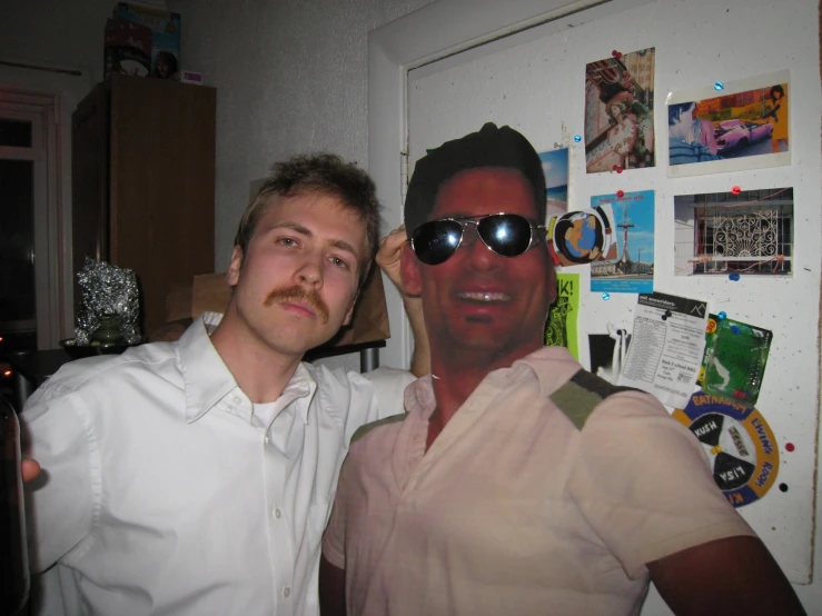 two men pose for a picture while wearing sunglasses