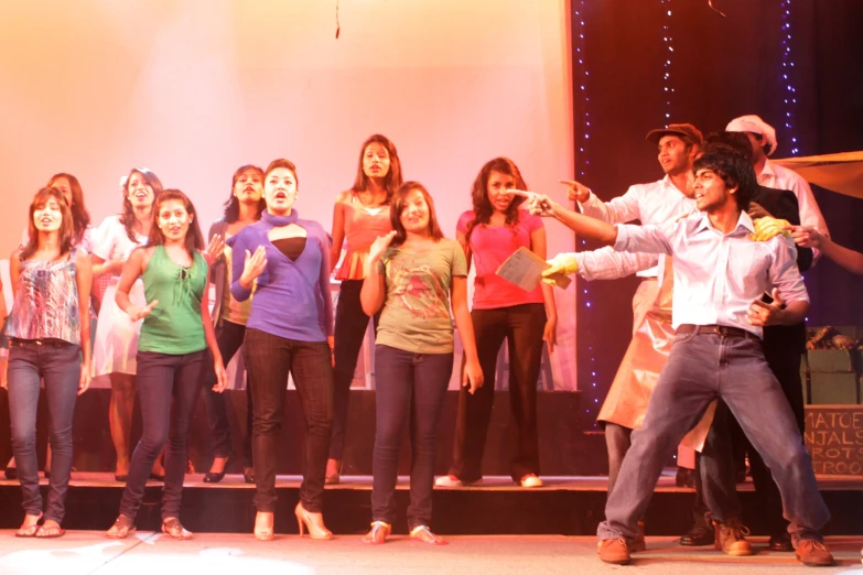 a group of children and adults on stage singing