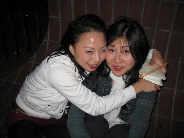 two beautiful young women sitting on the floor together