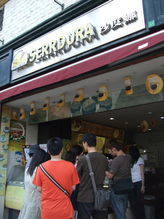 people in front of a coffee shop with a sign advertising their product