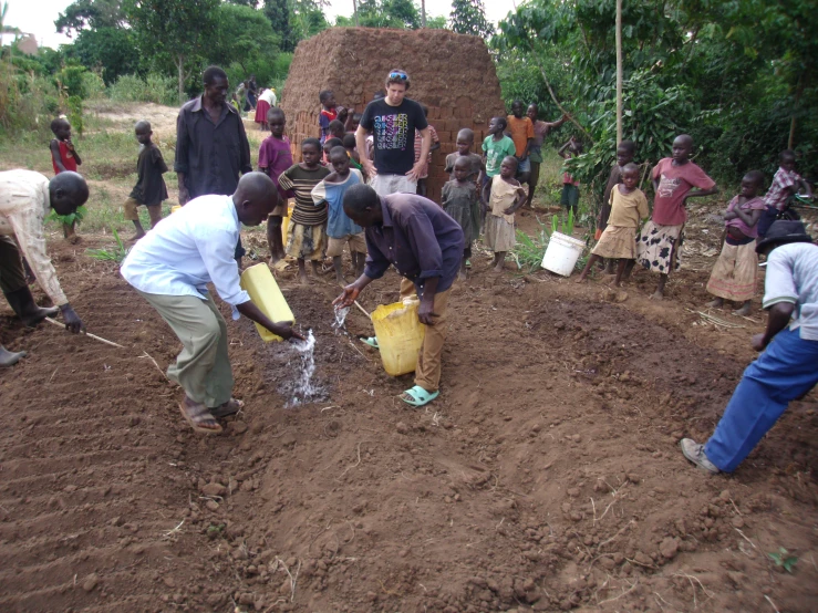 people in rural area gather around and collect water