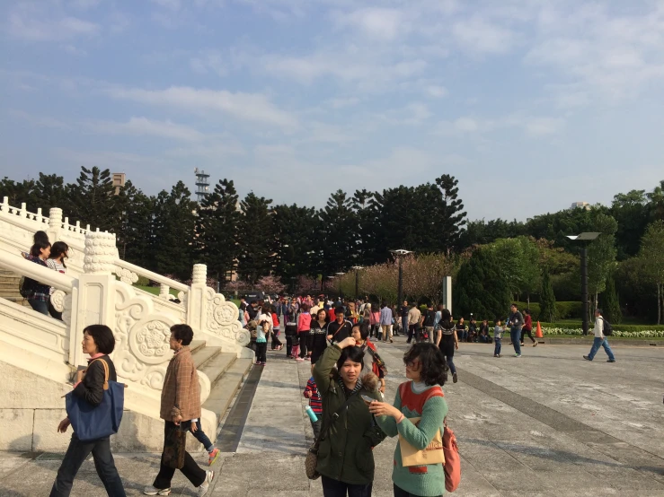 a large crowd is gathered at the park, and many people are walking around