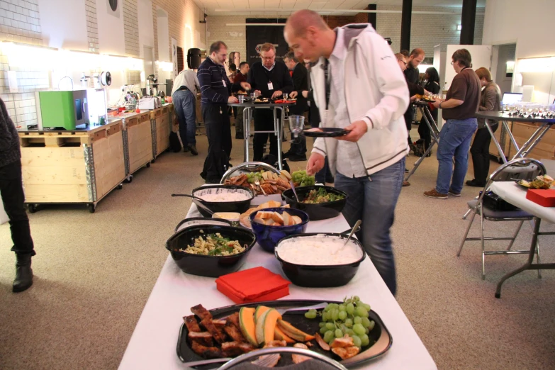 a group of people standing in front of a buffet table