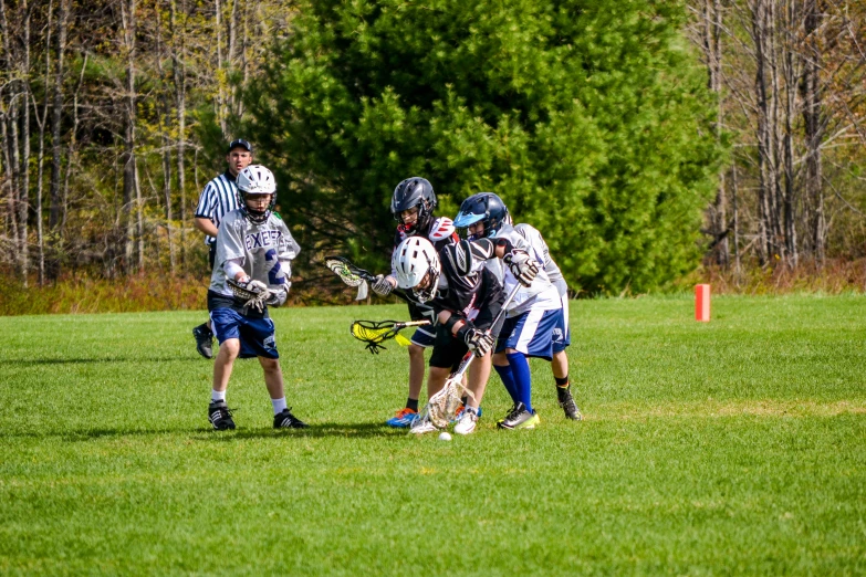 a group of s playing lacrosse on a green field
