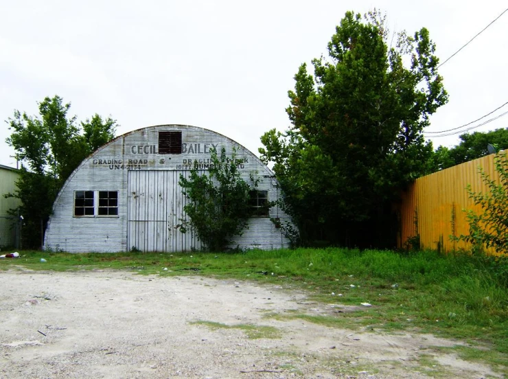 an old shed sits beside the old yellow house