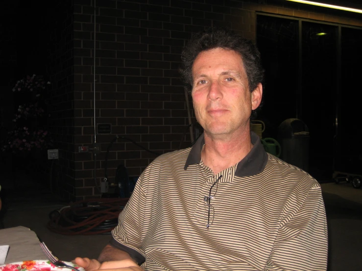 a man with a black and brown striped shirt on a table