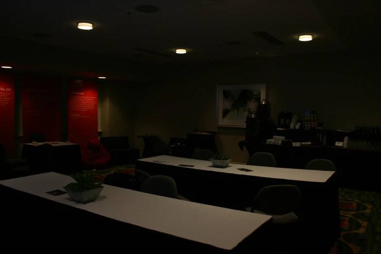 a dark room filled with tables and chairs