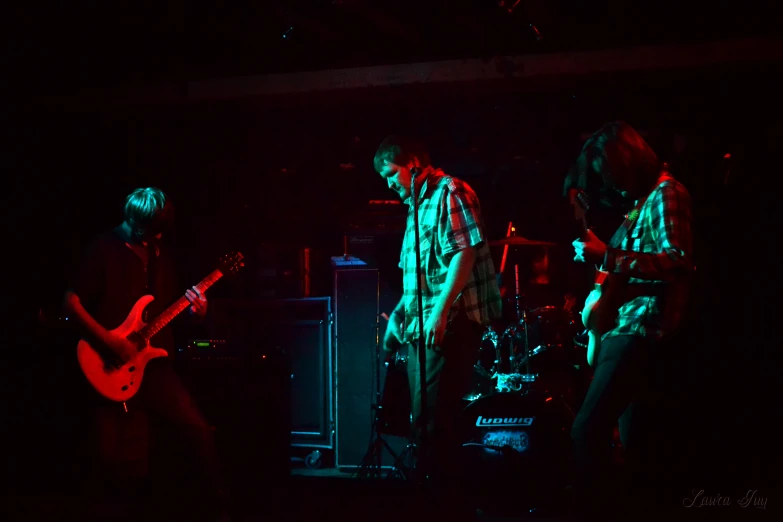 a band playing in a dark room with guitars