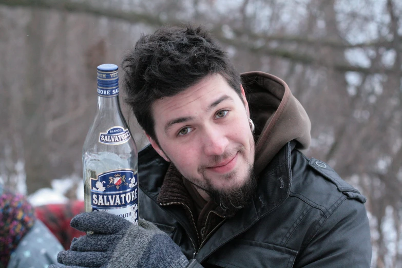 man holding up a bottled water in front of his face