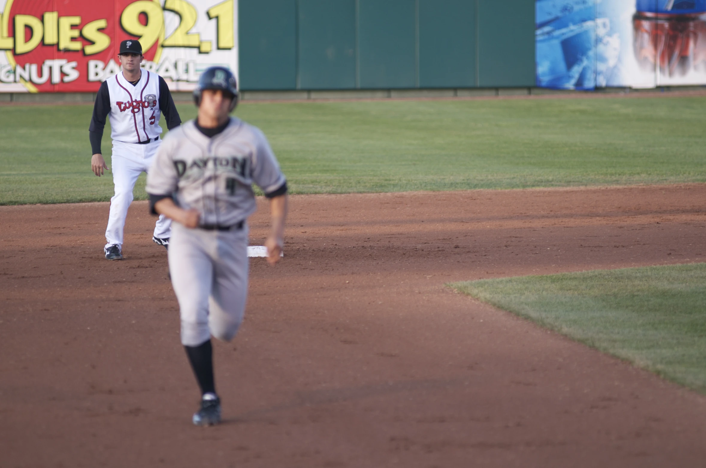 baseball players and onlookers play a game of softball