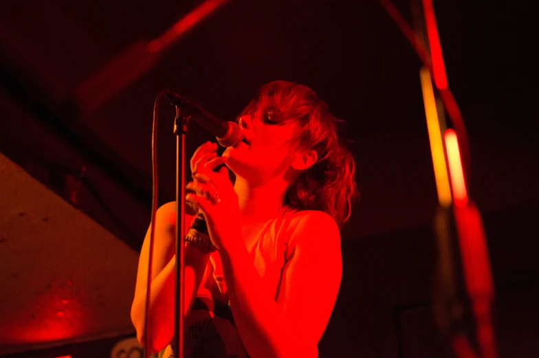 a female singing into a microphone in a dark room