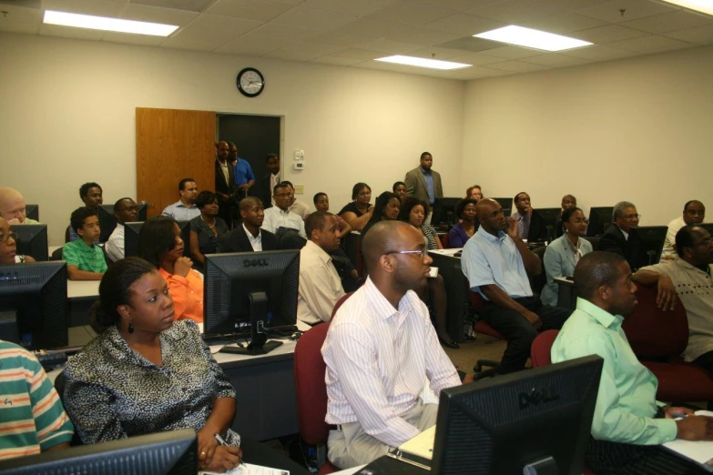 people sit in chairs listening to a speaker