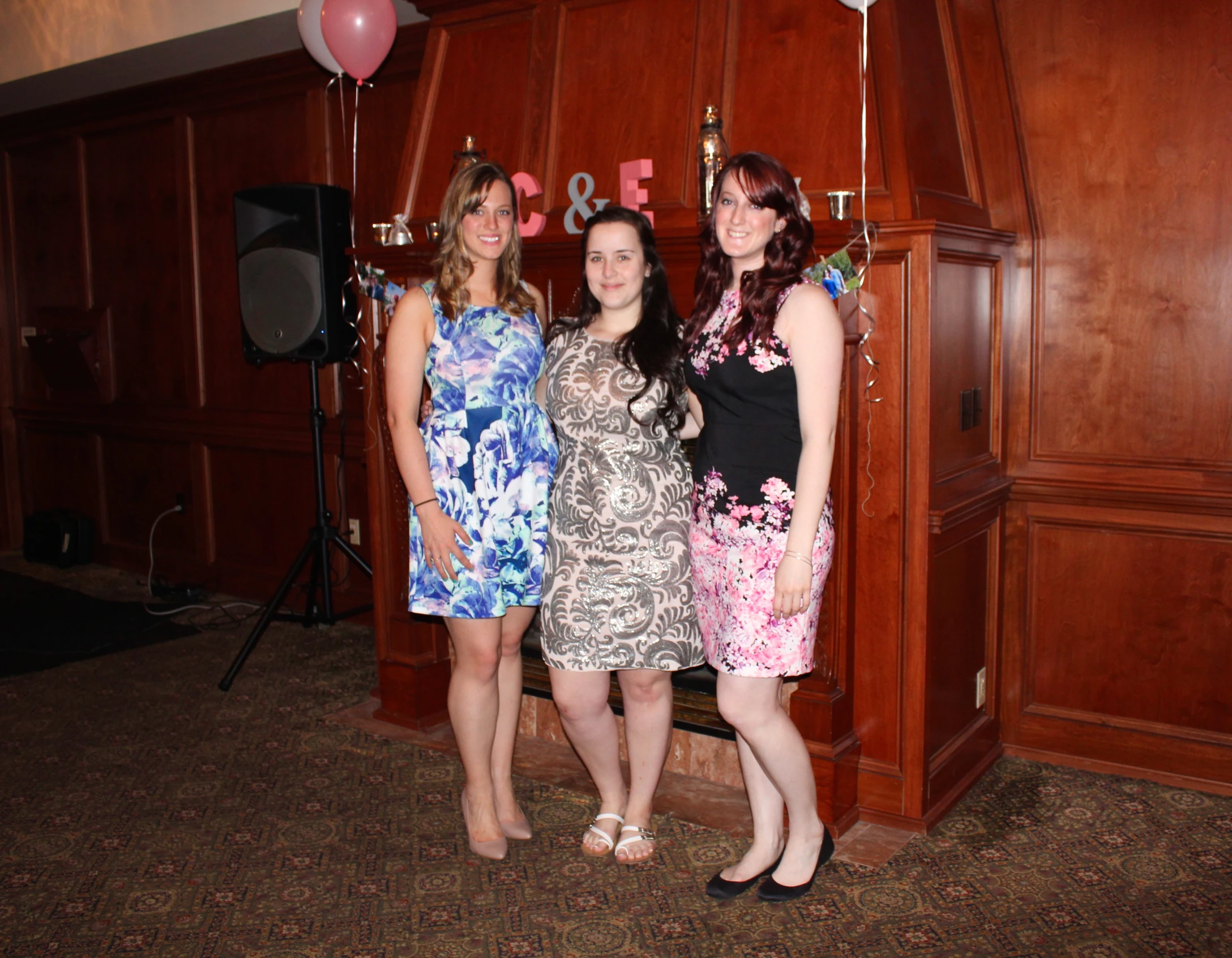 three women in cocktail dress posing together for the camera