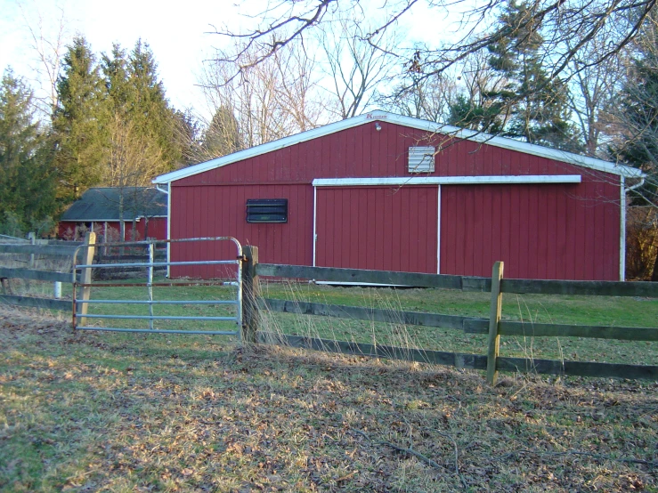a farm with red siding, a white building and green field