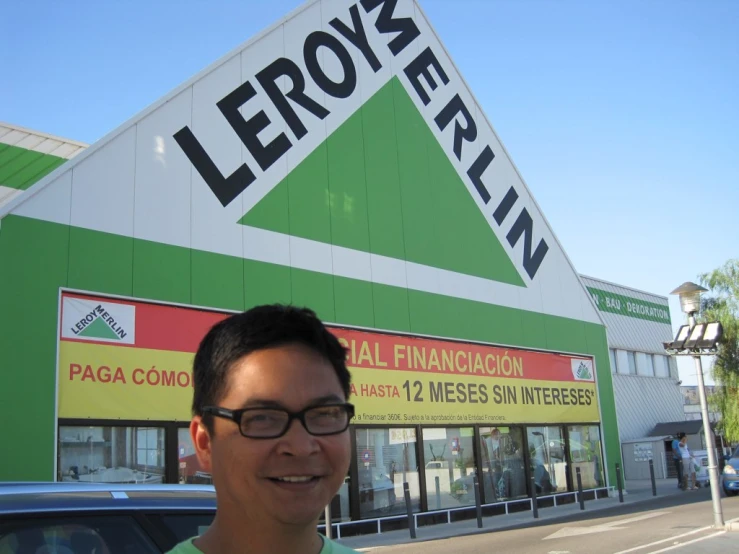 a man smiles near a store for the camera