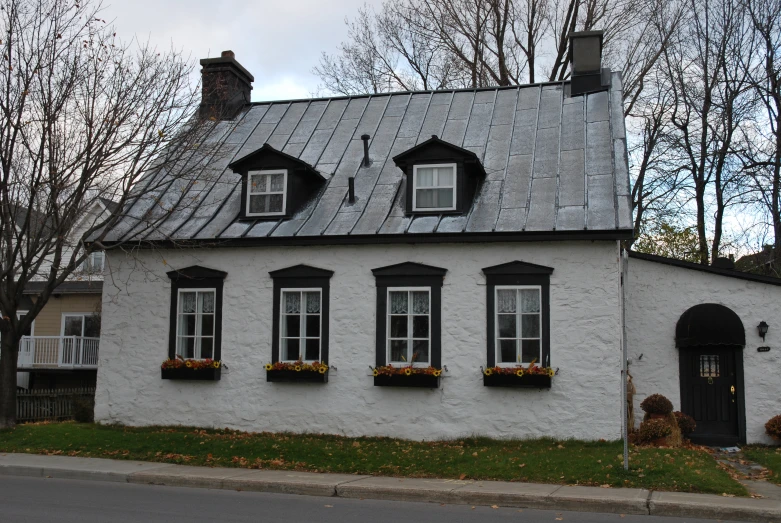 a white house with four windows on a street corner