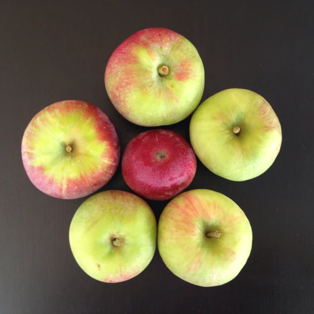 four apples sitting next to each other on top of a table