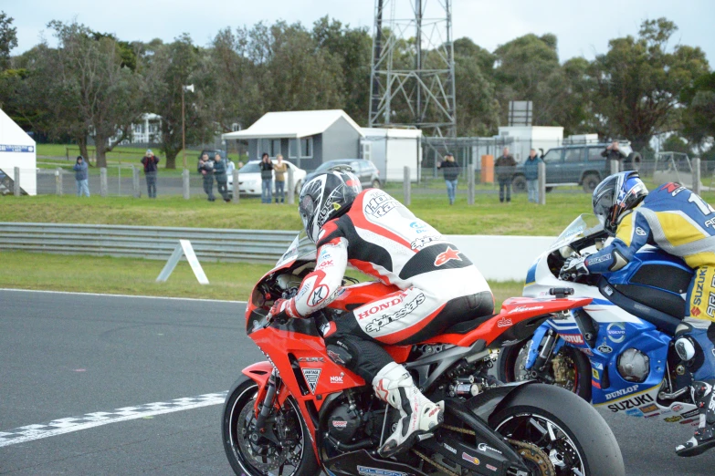 two motorcycle racers are racing on the same bike