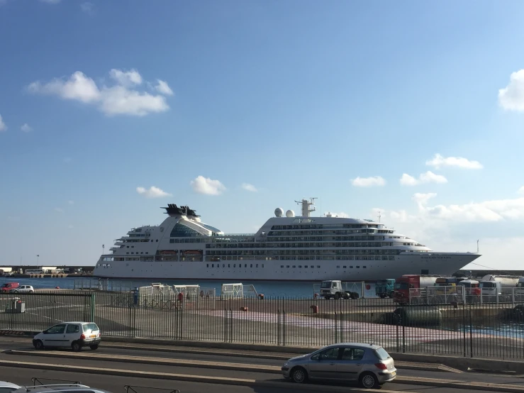 a passenger ferry is sailing by the terminal as traffic passes