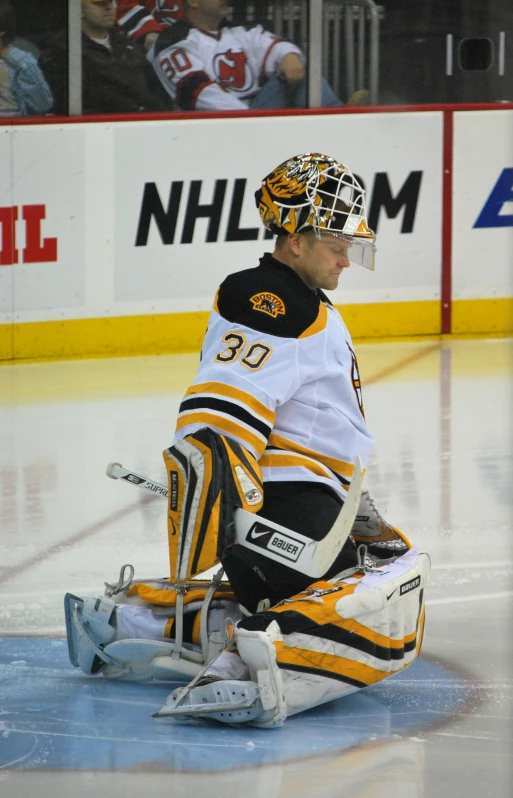 the goalie rests on the ice waiting for his turn