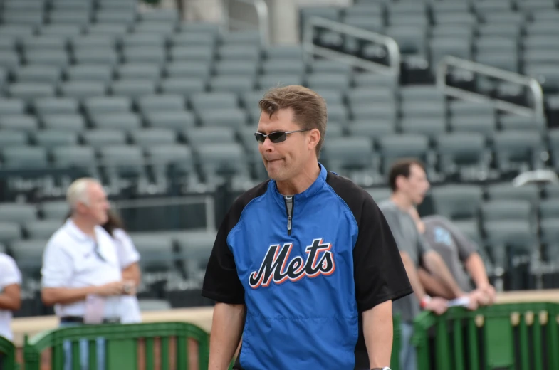 a man walks across the bleachers with sunglasses on