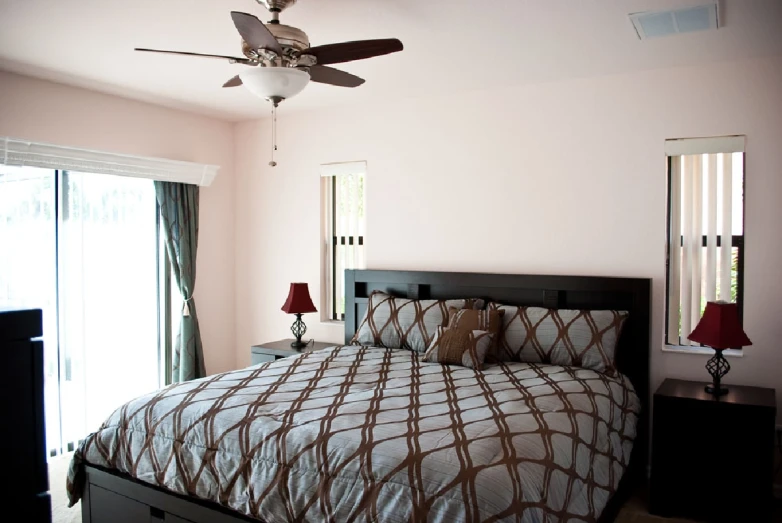 a bedroom with a ceiling fan and bed